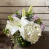 White and Lavender flowers, arranged in short vase. 