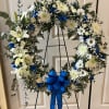 This beautiful white circular wreath with blue can be customized to fit