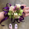 A classic white rose and green orchid with purple ribbon corsage compliments