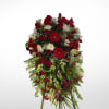 A red and white sympathy standing spray consisting of gerbera daisies, alstroemeria