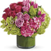 Blooms include green hydrangea, pink hydrangea, green cymbidium orchids, hot pink roses