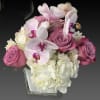 Pink Phalaenopsis orchids with purple roses complemented by white hydrangeas. Simple and