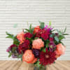 A full cranberry tones fresh flower arrangement with rich reds, purples, and