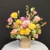 Lovely Pink, Peach and Yellow Blooms arranged organically in a gold cylinder.