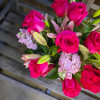 This arrangement features hot pink roses and light pink supporting florals including