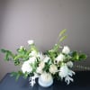 A seasonal variety of white blooms with accent greenery and texture.