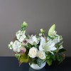 A seasonal variety of white blooms with accent greenery and texture.