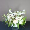 A seasonal variety of white blooms with accent greenery and texture.