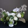 A seasonal variety of white blooms with accent greenery and texture.