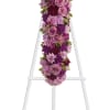 A breathtaking standing cross of majestic purple and lavender blooms remembers and