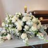 Classic Casket spray featuring white roses, white snap dragon, white chrysanthemums, white