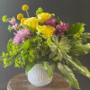 Bright and cheery bouquet in a sweet little vessel, sure to brighten