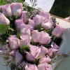 24 purple roses with purple fillers, wrapped.  Glass vase not included