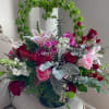 Romantic blossoms and colors gathered in a glamorous container to celebrate love