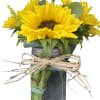 Beautiful mason jar with sunflowers, some filler flowers and greenery with a