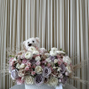 This playful arrangement features a cuddly white teddy bear nestled amongst a