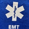 A 50&quot; x 60&quot; throw quilt with white EMT symbol on a