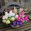 A beautiful floral arrangement featuring dendrobium orchids and phaleanopsis orchids. Deep purple