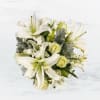 This arrangement includes white roses, white asiatic lilies, white stock, and dusty