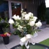 One dozen roses, assorted filler and greenery in a clear vase.