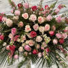 Roses, lilies, and more come together for a blushing pink half casket