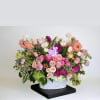 A low arrangement using premium orchids, dahlias, and roses.
