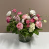 This arrangement has a mix of flowers including hydrangeas, roses, tulips, and