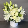 This floral design is arranged in a ehite ceramic vase. Imported and