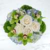 A blue and green arrangement in a stylish silver vase, this arrangement