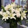 White roses and white lilies, arranged in Clear glass vase with Ti
