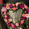 An array of pinks in the shape of a heart displayed on