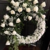 A fresh wreath consisting of White Roses and White Cushions mixed with