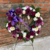 A fresh wreath easel consisting of Purples and Whites 
*Specify word on