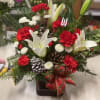 A bouquet of red and white paired with pine cones arranged in