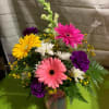 A colorful bouquet with a variety of flowers arranged in a designer