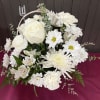 An arrangement of all white flowers arranged in a basket 