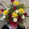 A combination of red, white, and yellow flowers arranged in a white