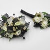 A boutonniere and wrist corsage featuring white larkspur, black ribbon &amp; black
