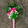 Select this bright bold pink boutonniere of spray roses, babies breath and