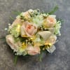A wrist corsage and boutonniere set with light pink spray roses, white