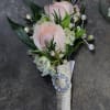 A boutonniere with light pink spray roses, white larkspur blooms, rhinestones.

If you