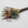 A boutonniere featuring succulents, chocolate brown ribbon and a rhinestones.

Depending on availability