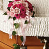 This delicate combination of spray roses and carnations hand-tied with pink satin