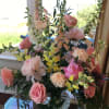 Tall vase arrangement with foxglove, peony, carnations, and roses in a low
