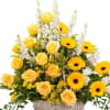 A white wicker basket filled with a beautiful selection of yellow flowers