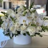 A stunning basket arrangement marrying the classic elegance of white roses with