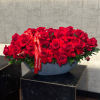 A stunning vase adorned with vibrant red roses and ranunculuses exudes passion