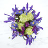 A white box vase, green roses, and vivid blue iris make this