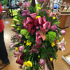 Standing spray with pink lilies, green hydrangea, pink roses, yellow daisies, and