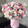In a charming pink box, a breathtaking arrangement awaits, exuding delicate beauty